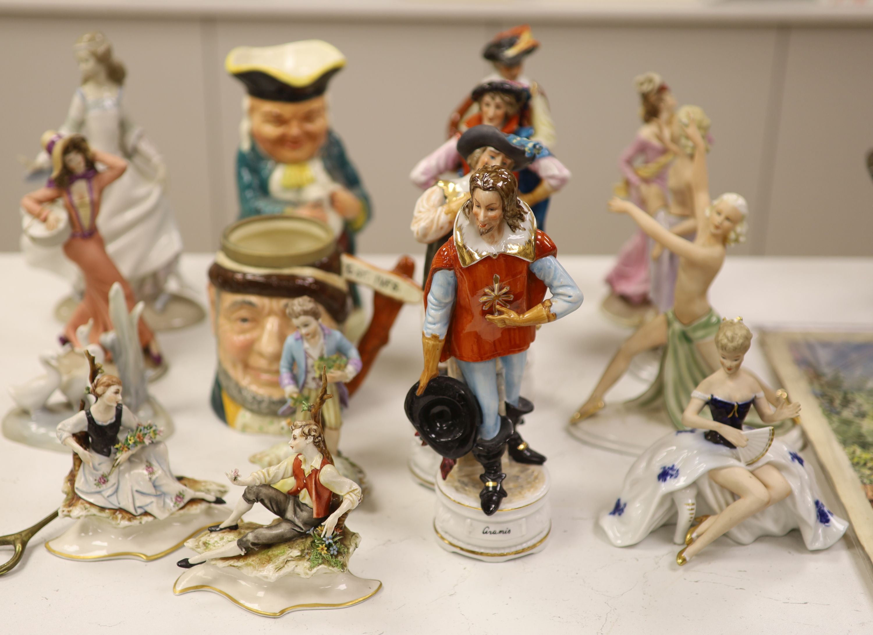 A group of porcelain figurines and two Toby jugs